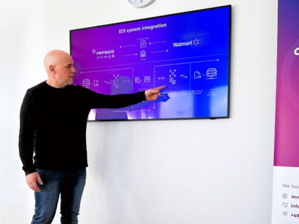 Ein Mann präsentiert etwas vor einem Bildschirm